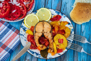 The best recipe of salmon baked with vegetables and lemon on a wooden table