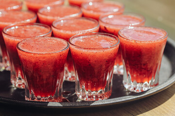 Summer fruit vodka shots. Frozen berry mix blended with alcohol. Bright red color in clear glasses....