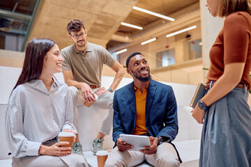 Group of multi-ethnic businesspeople having an informal meeting in a modern office building,...