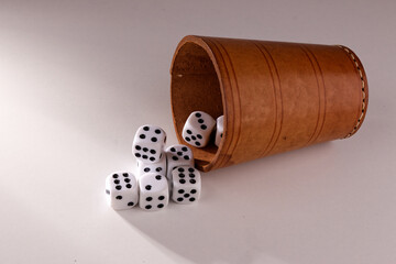 A random arrangement of dice and a puzzle cup, captured after the dice have been cast.