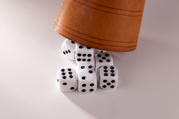 A random arrangement of dice and a puzzle cup, captured after the dice have been cast.