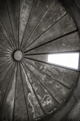 Looking up inside an old farm silo with sun shining through monochrome background