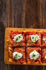 Pizza al metro margherita with burrata cheese on wooden table