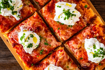 Pizza al metro margherita with burrata cheese on wooden table