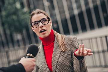 Confident businesswoman giving an outdoor interview on urban street in professional attire