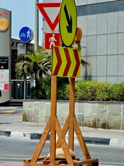 Traffic signs on wooden stands, including yield, detour, pedestrian, and cyclist signs, near a...