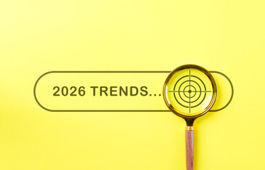 2026 Trends Search Concept. Yellow background with search 2026 Trends, magnifying glass focusing on...