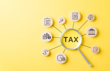 Tax Concept. Wooden blocks with tax related icons connected to magnifying glass highlighting TAX on...