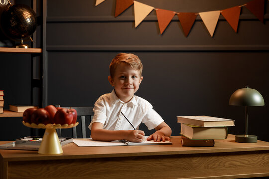 Child Doing Homework with Books and Globe &ndash; Back to School Theme