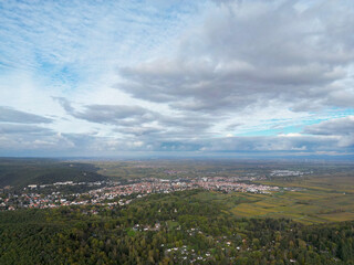 Scenic aerial view of a picturesque European village with red-tiled roofs nestled between lush...