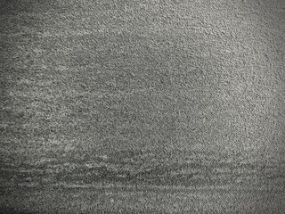 Close-up of a textured gray concrete wall with a rough surface and subtle shadows. Ideal for backgrounds, architectural design, or industrial-themed visuals.