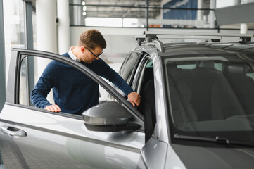 Handsome bearded buyer in casual wear in dealership