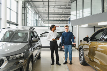 A consultant at a car dealership helps a customer choose a new car