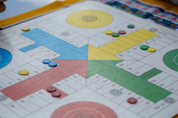 Colorful parcheesi board game with pawns ready for playing