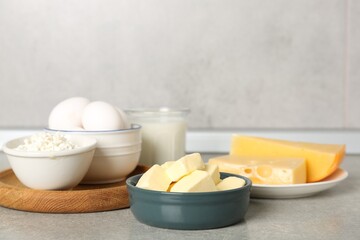 Different dairy products and eggs on gray textured table in kitchen, closeup