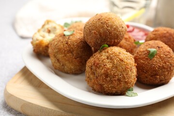 Delicious fried croquette balls with parsley and ketchup on grey textured table, closeup