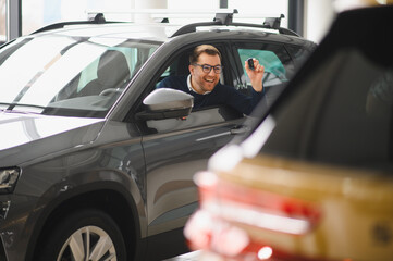Happy man showing the key of his new car