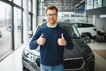 I got a new car today. Portrait of a happy mature man smiling posing near his new car at the local...