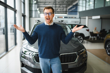 Young man is choosing a new vehicle in car dealership