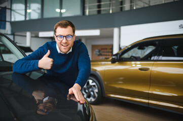 Young man is choosing a new vehicle in car dealership