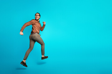 Energetic young professional dressed in elegant business attire leaping enthusiastically on a...