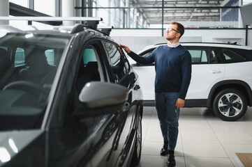 I got a new car today. Portrait of a happy mature man smiling posing near his new car at the local...