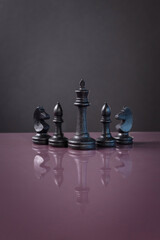 chess piece on purple surface on dark background as business strategy for chess game