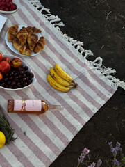 Outdoor Picnic with Fruits, Croissants, and Wine