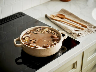 Hearty mushroom soup simmering in a creamy pot on a stove