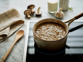 Hearty mushroom and grain porridge cooking on a stove