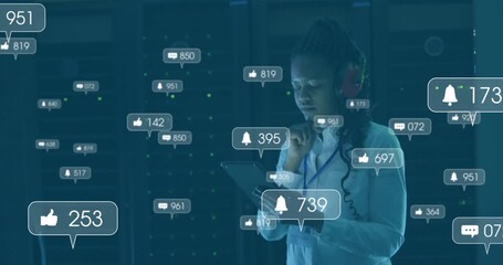 IT specialist tapping tablet in server room activating social media metrics floating around her - Powered by Adobe