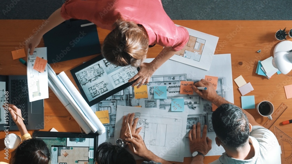Poster civil engineer team checking at sticky note while standing at meeting. top view of designer working 