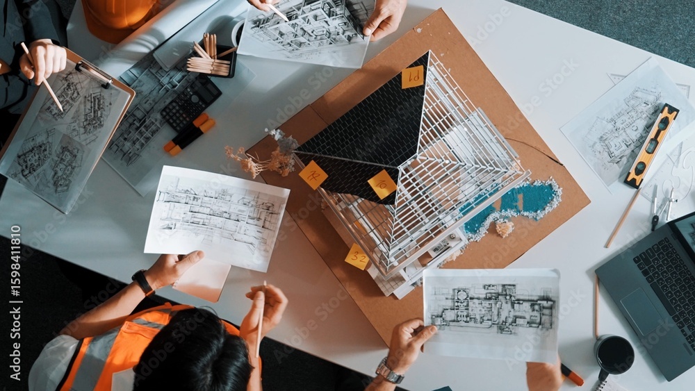 Poster top view of manager handed blueprint to professional engineer team at meeting table with house model