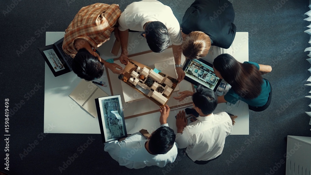 Poster top down view of manager pointing at house model and explain building design. aerial view of archite