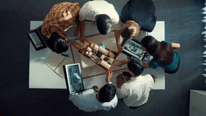 Top down view of manager pointing at house model and explain building design. Aerial view of...