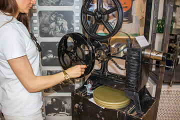07.07.2025 - Minsk, Belarus - Woman examining vintage film projector at the cinematography museum. Culture