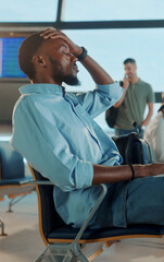 Stressed businessman touching head waiting for flight in airport lounge