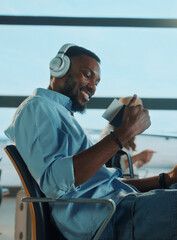 Happy passenger wearing headphones holding passport and ticket at airport