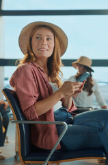 Tourist using smartphone in airport lounge waiting for flight departure