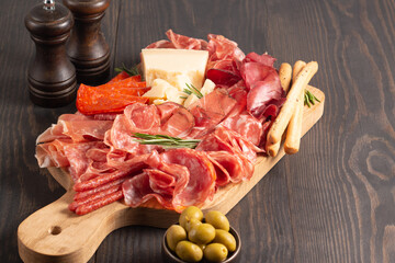 Charcuterie board. Antipasti appetizers of meat platter with salami, prosciutto crudo or jamon and...