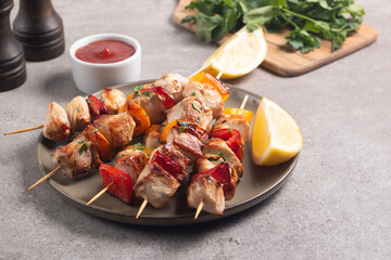Delicious grilled chicken skewers with capsicum, lemon, salad and ketchup on a plate over the table. Chicken kebab. Healthy food concept.