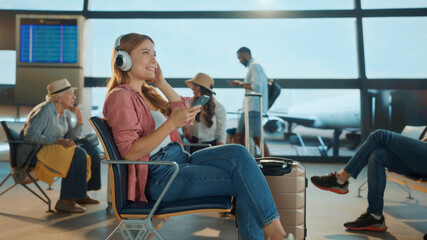 Tourist listening to music while waiting at the airport gate