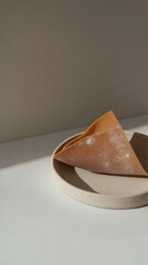 Close-up view of uncooked pasta shells stacked on a smooth surface. The warm background enhances their unique ridged texture and delightful curves.