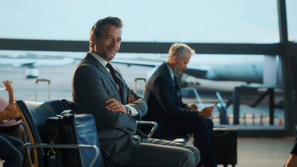 Businessman smiling in airport lounge waiting for flight departure