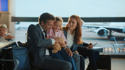 Family waiting at the airport business lounge embracing each other