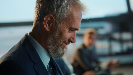 Senior businessman smiling in airport business lounge