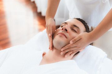 Caucasian man enjoying relaxing anti-stress head massage and pampering facial beauty skin...