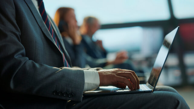 Businessman working on laptop in airport lounge - Powered by Adobe