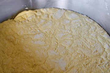Dough resting in troughs at a bustling bread factory during morning hours