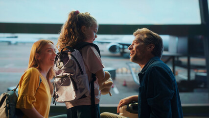 Obraz premium Happy family saying goodbye at airport terminal before boarding